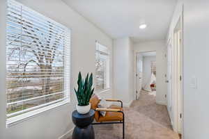 Hallway featuring light carpet and baseboards