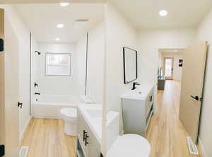 Full bath featuring vanity, light wood-style flooring, tub / shower combination, and recessed lighting
