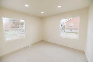 Spare room with light colored carpet, recessed lighting, and healthy amount of natural light