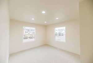 Empty room with recessed lighting and light carpet
