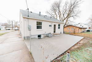 Rear view of property with a patio, brick siding, and a shingled roof