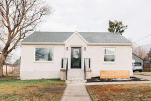 Bungalow featuring roof with shingles and brick siding