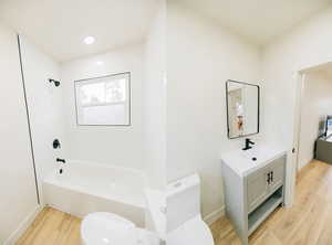 Full bathroom with light wood-style flooring, vanity, and shower / bathtub combination