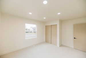 Unfurnished bedroom featuring a closet, carpet, and recessed lighting