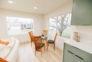Dining room with light wood-style floors and recessed lighting