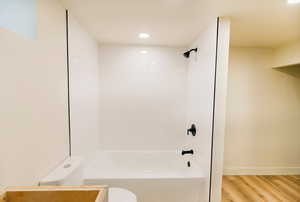 Full bath with wood finished floors, shower / bath combination, and recessed lighting
