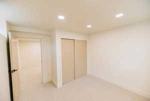 Unfurnished bedroom featuring a closet, carpet flooring, and recessed lighting