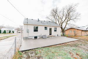 Rear view of property featuring a patio area and roof with shingles