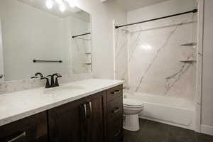 Full bath with vanity, washtub / shower combination, and dark tile patterned floors