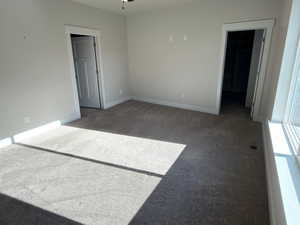 Spare room featuring dark colored carpet, ceiling fan, and recessed lighting