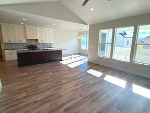 Unfurnished living room featuring vaulted ceiling, dark wood finished floors, ceiling fan, and recessed lighting