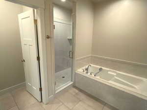 Bathroom featuring a stall shower, a bath, light tile patterned floors, and recessed lighting