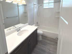 Full bathroom featuring vanity, dark wood-style floors, a textured ceiling, and bathtub / shower combination