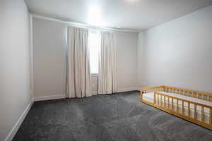 Unfurnished bedroom featuring dark carpet and a textured ceiling