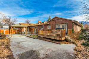 View of front of house with a gazebo, brick siding, concrete driveway, a deck, and a patio