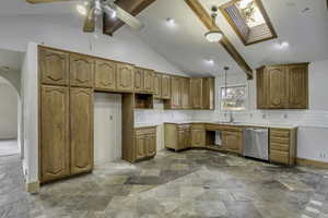 Kitchen featuring backsplash, decorative light fixtures, dishwasher, and light countertops