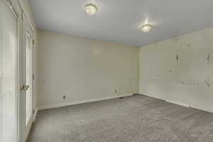 Spare room featuring light colored carpet and baseboards
