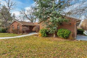 Ranch-style home featuring a front lawn and brick siding