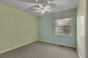 Spare room featuring carpet and ceiling fan