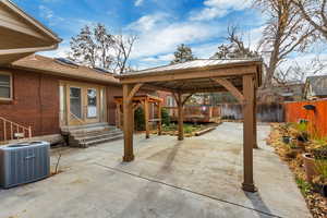 Fenced backyard featuring a gazebo, a patio, and french doors