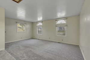 Carpeted empty room featuring baseboards