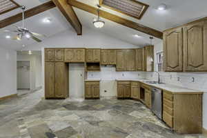 Kitchen featuring decorative light fixtures, tasteful backsplash, light countertops, brown cabinets, and dishwasher