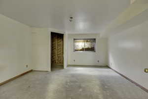 Unfurnished room with baseboards and concrete flooring