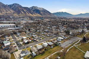 Aerial view of property and surrounding area with a mountainous background and nearby suburban area