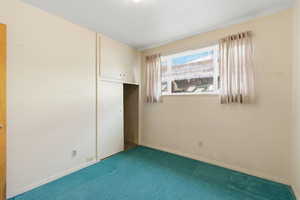 Unfurnished bedroom featuring carpet flooring and a closet