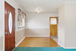 Foyer with light wood-type flooring and track lighting