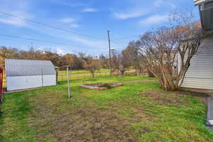 View of yard with a vegetable garden and a shed