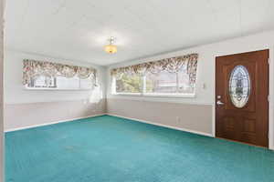 Carpeted foyer with baseboards