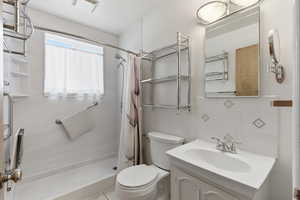 Full bathroom featuring decorative backsplash, vanity, and a shower stall