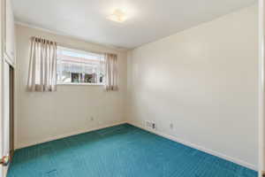 Carpeted empty room featuring baseboards