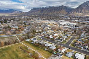 Aerial view of property and surrounding area with nearby suburban area and mountains