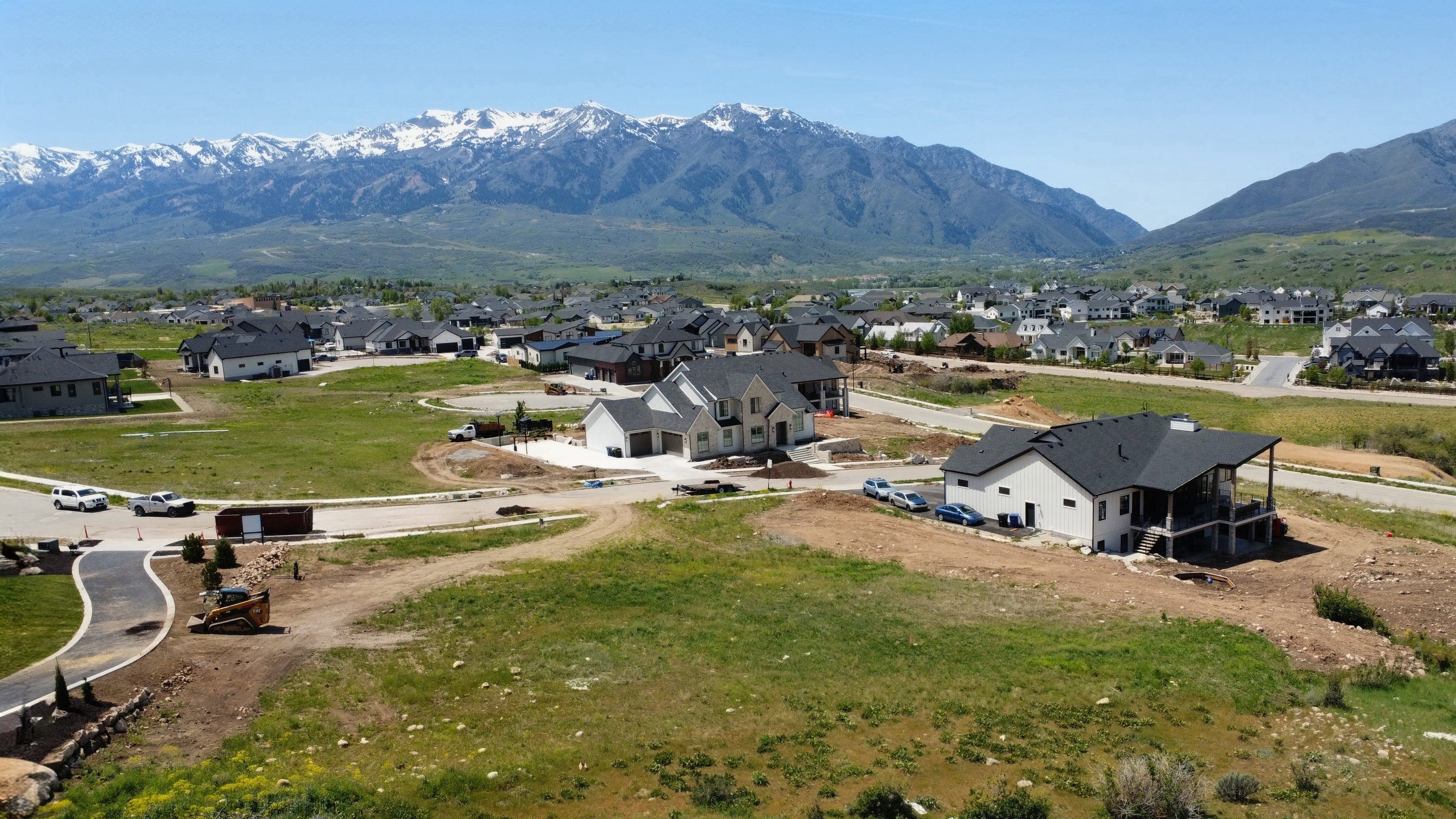 Expansive mountain backdrop featuring snow-capped peaks and green foothills