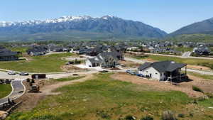 Expansive mountain backdrop featuring snow-capped peaks and green foothills