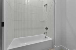 Bathroom featuring bathtub / shower combination and baseboards