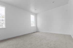 Carpeted empty room featuring baseboards