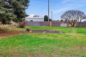 View of fenced backyard and firepit