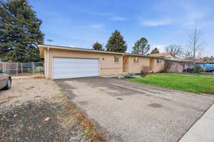 Ranch-style home featuring brick siding, asphalt driveway, and a garage