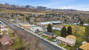 Aerial view of residential area with a mountain backdrop and the city owned open space area behind the home