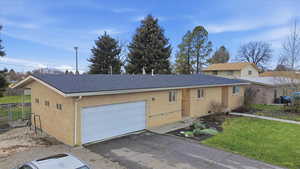 View of front facade with roof with shingles, driveway, a garage, and brick siding