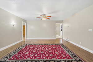Large living room featuring light wood-type flooring and ceiling fan