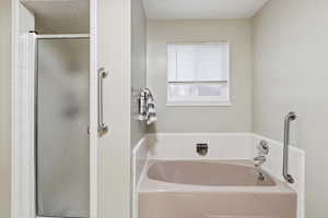 Full bath with a shower stall and a garden tub