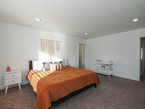Bedroom with recessed lighting, dark colored carpet, and a textured ceiling