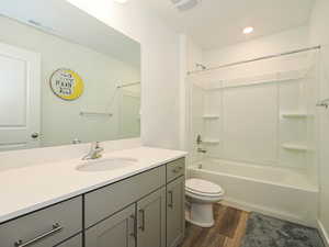 Full bathroom featuring bathing tub / shower combination, vanity, dark wood-type flooring, and recessed lighting