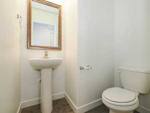 Half bath featuring baseboards and dark wood finished floors