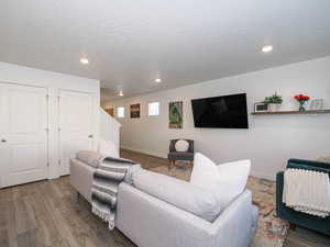 Living area with recessed lighting, wood finished floors, and a textured ceiling
