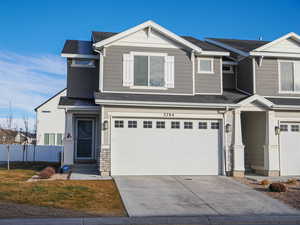 Craftsman-style house featuring roof with shingles, concrete driveway, and a garage